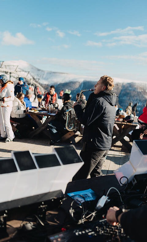 Mann mit Saxophon und Menschenmenge im Hintergrund beim Nock Beats Event