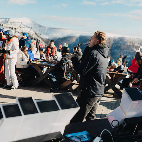 Mann mit Saxophon und Menschenmenge im Hintergrund beim Nock Beats Event