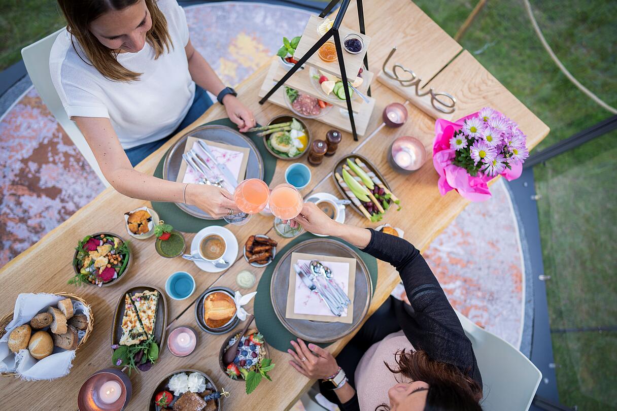 2 Personen genießen ihren Brunch mit Leckereien in der Glaskuppel