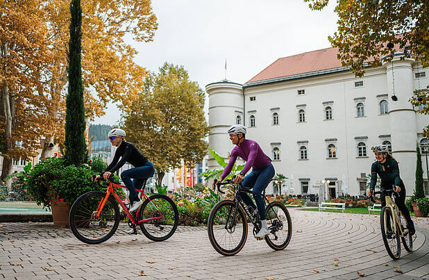 Drei Personen mit Gravelbikes vor dem Schloss Porcia