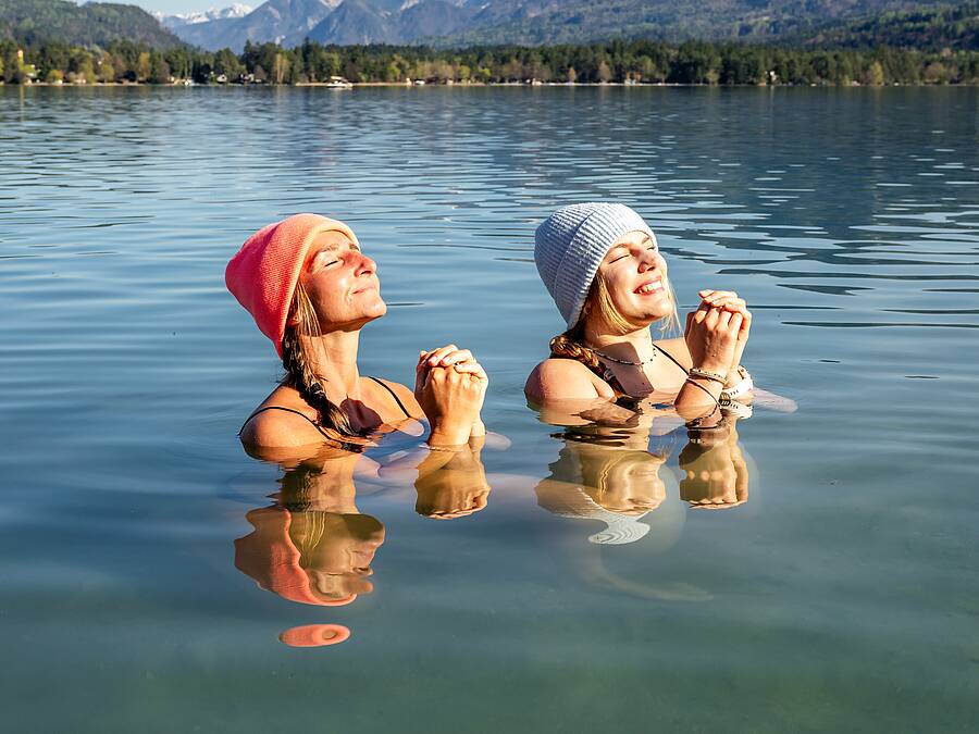 2 Frauen genießen beim Kaltbaden im Faaker See die Sonne