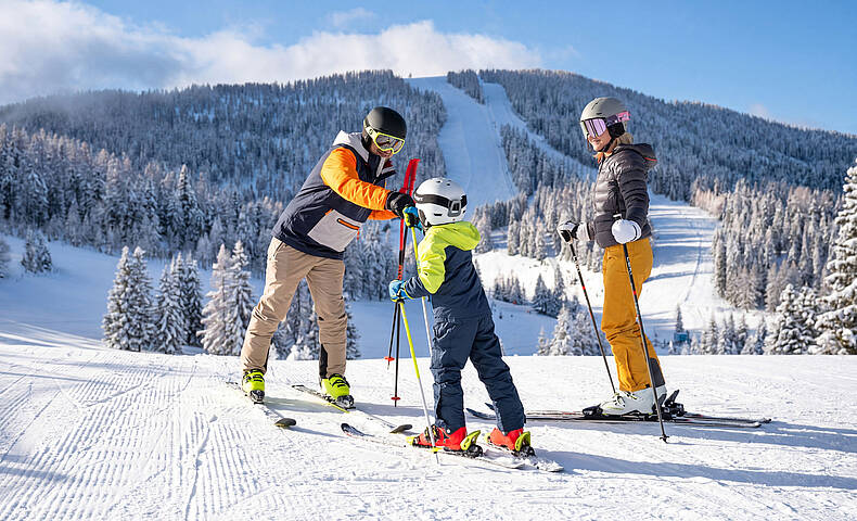 Familie genießt einen Wintertag auf den Skipisten der Hochrindl in Kärnten