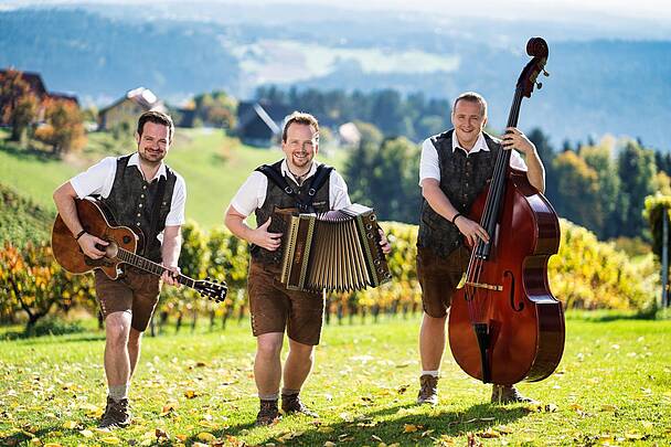 Die Pagger Buam mit Akkordeon, Gitarre und Kontrabass spielen traditionelle Volksmusik aus Kärnten im Freien
