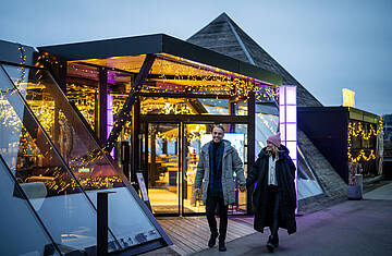 2 Personen gehen am Abend aus dem Kap am Millstätter See hinaus 