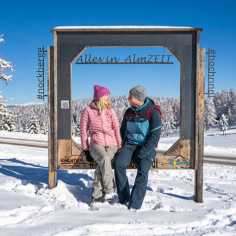 Paar am ZEITplatz Alles in AlmZEIT auf der Hochrindl in den verschneiten Nockbergen