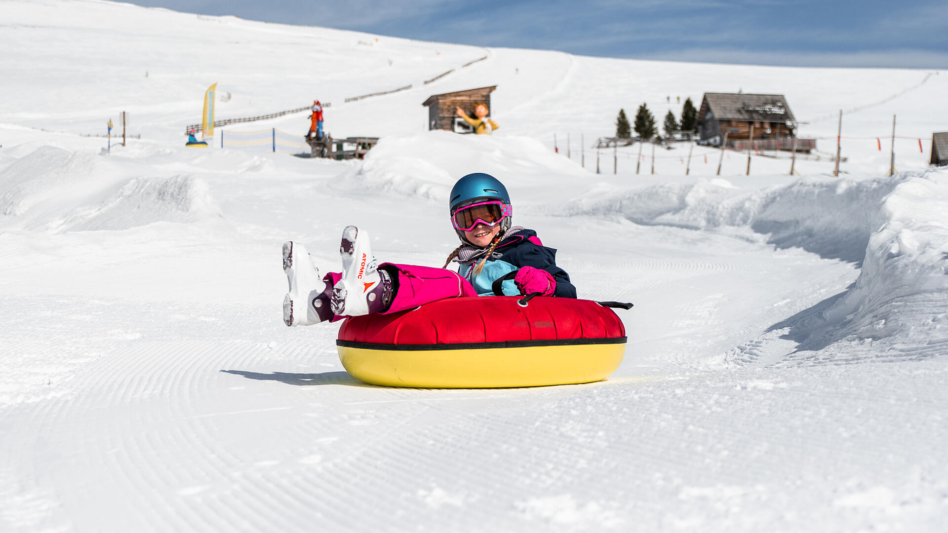 Geheimtipp: Skiurlaub mit Kindern am Falkert Kind fährt mit einem Tubing-Reifen den Berg hinunter