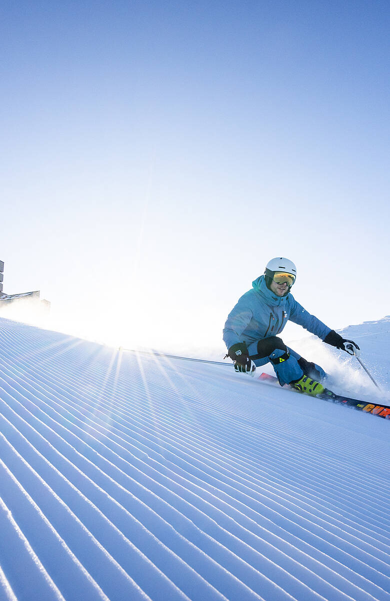 Skifahrer carvt über perfekt präparierte Piste in Bad Kleinkirchheim