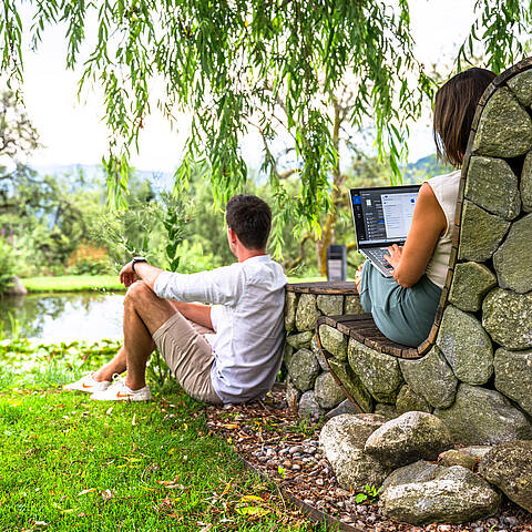 Workation in Kärnten – Frau arbeitet mit Laptop in der Natur. Remote Work in den Alpen zwischen Millstätter See und Nockbergen