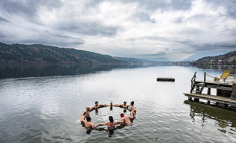 Personen bilden einen Kreis im Millstätter See beim Kaltbadeworkshhop