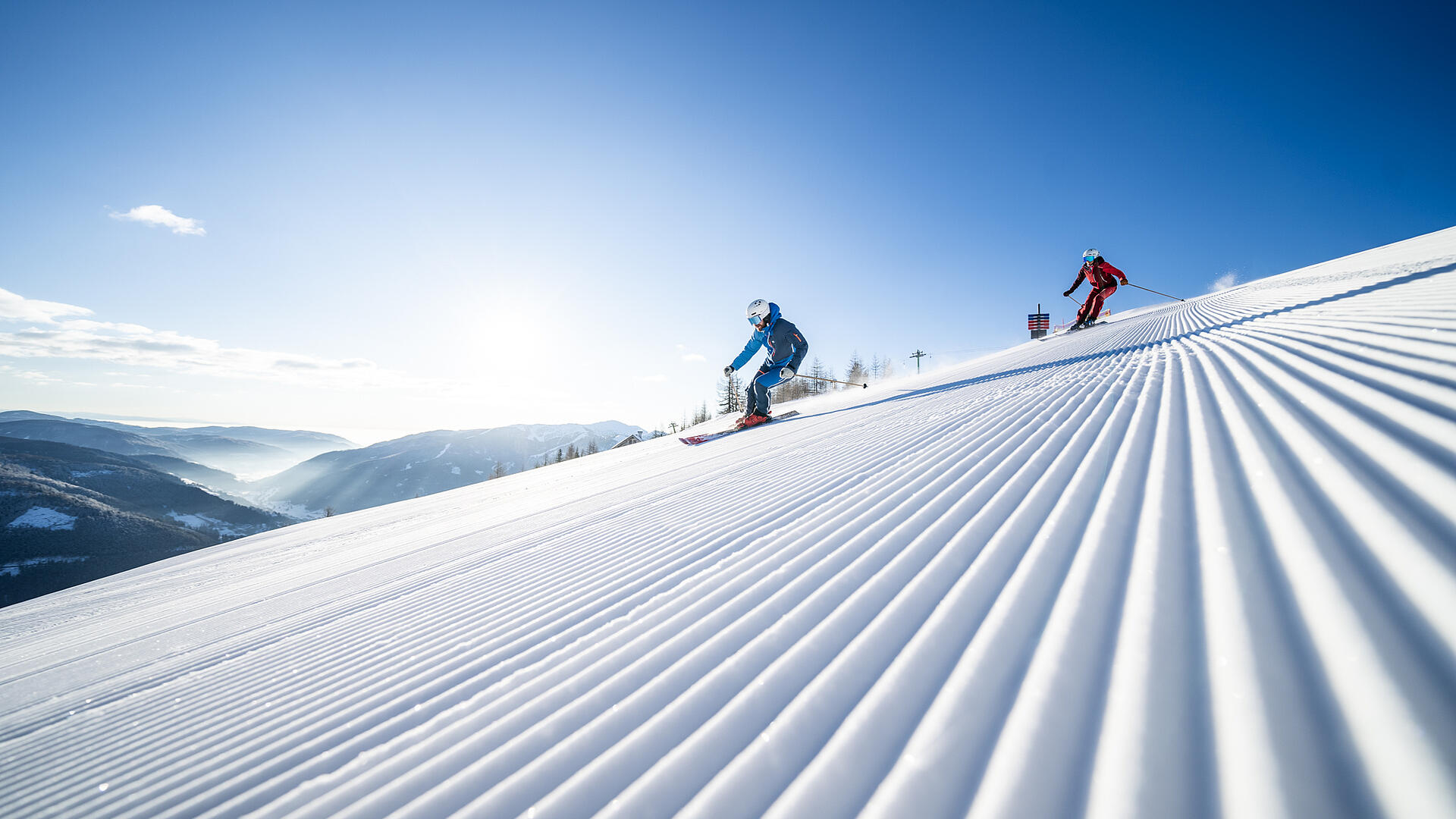 Skifahrer fahren die frisch präparierte Piste in Bad Kleinkirchheim hinunter