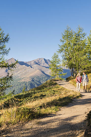 Wanderer auf Etappe 1 des Nockberge Trail im UNESCO Biosphärenpark mit Blick auf alpine Gipfel Richtung Neue Bonner-Hütte.