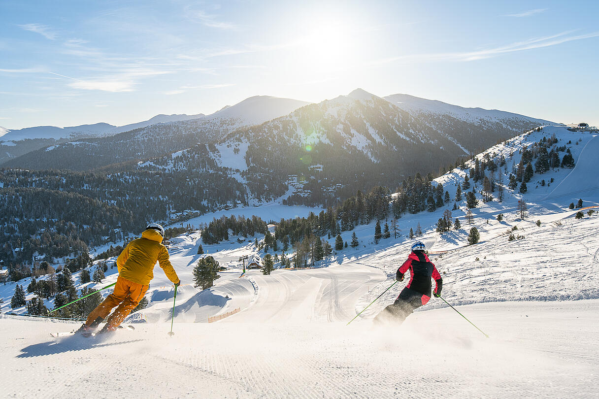 Skifahrer genießen das Herunterfahren der Piste bei Sonnenschein auf der Turracher Höhe