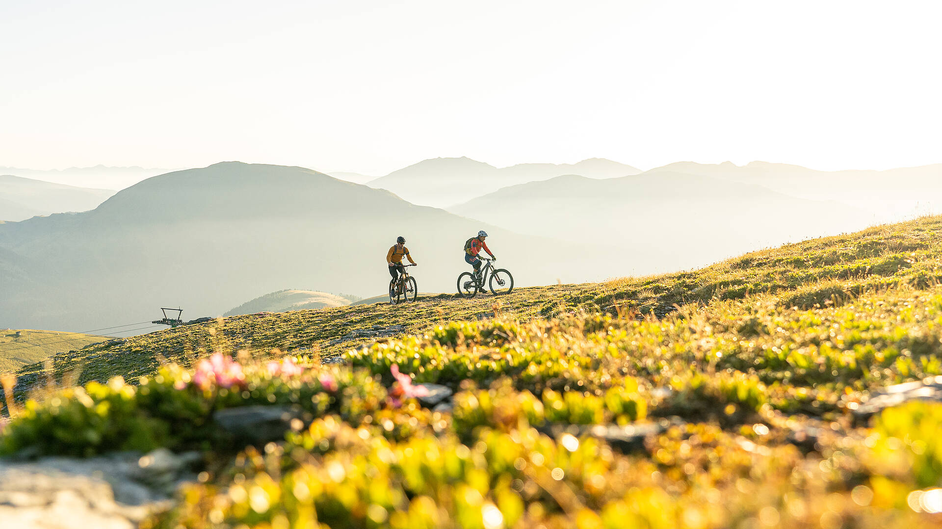 2 Personen radeln in den Nockbergen einen Gipfel hinauf