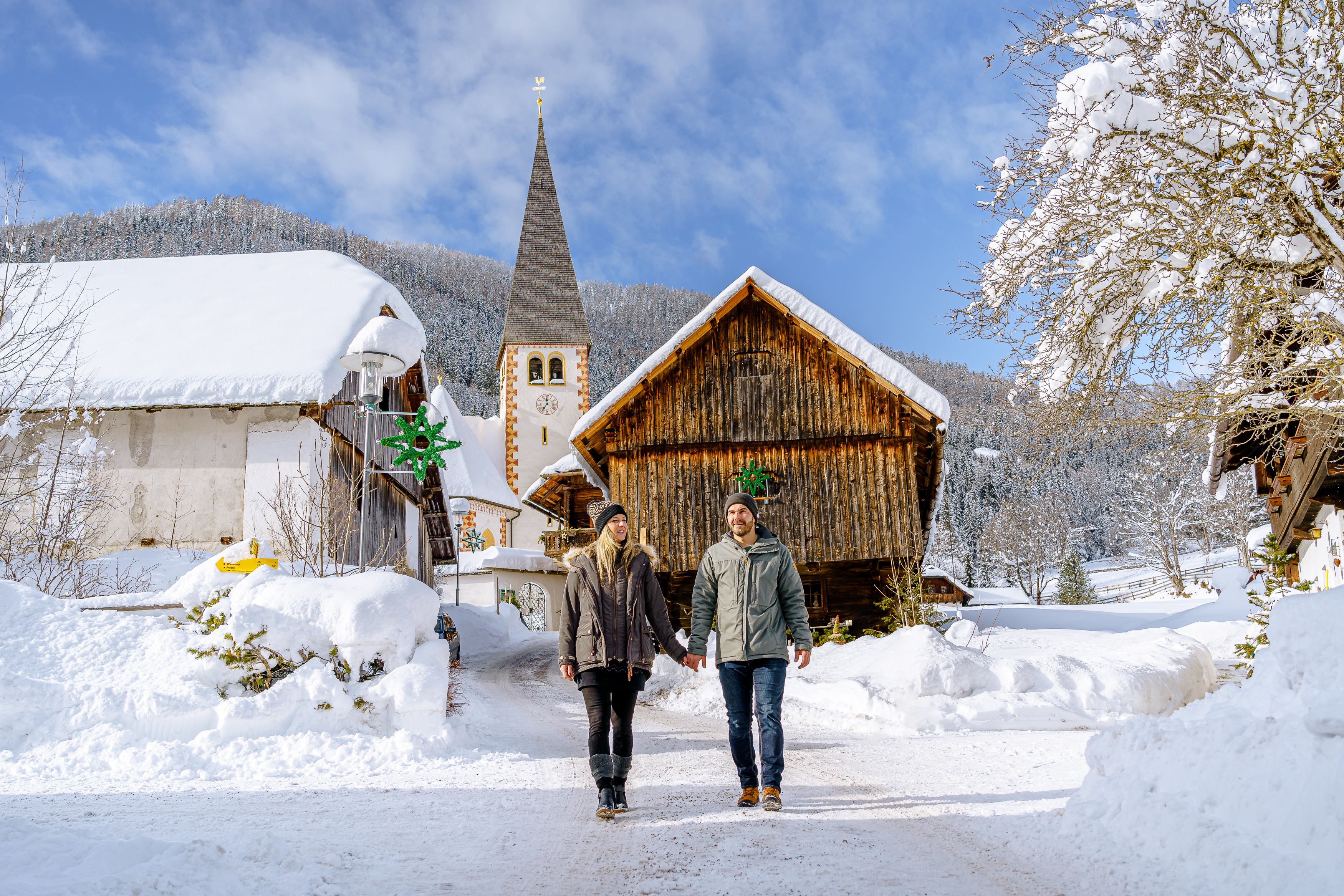 Pärchen spaziert vor einer Hütte im Schnee in Bad Kleinkirchheim